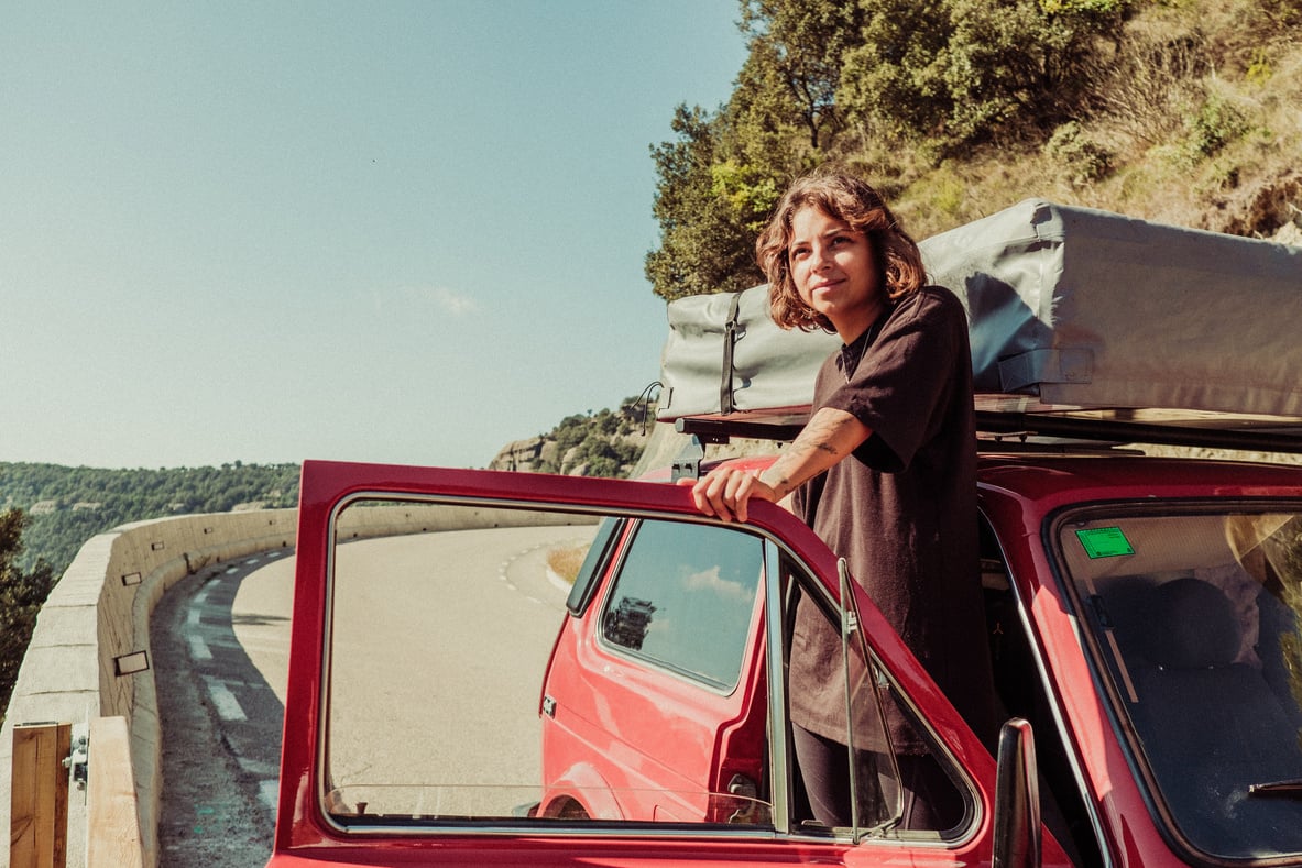 Man Getting off of Red Camper Van